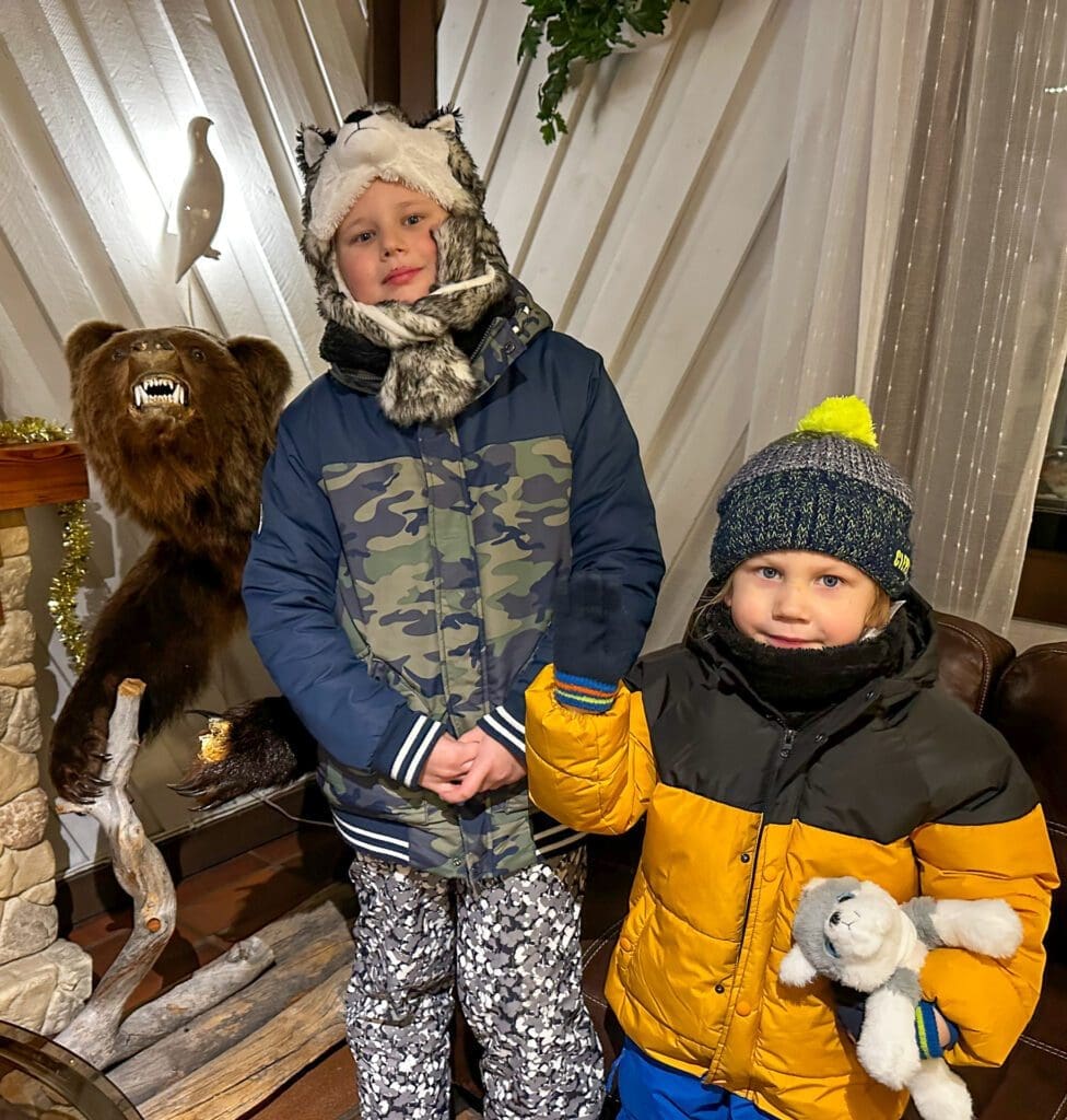 Rovaniemi: chłopcy w zimowych ubraniach przy figurach zwierząt