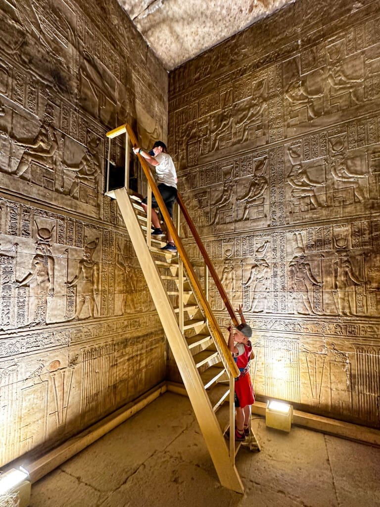Chłopcy na drewnianej drabinie w komorze świątyni Hathor